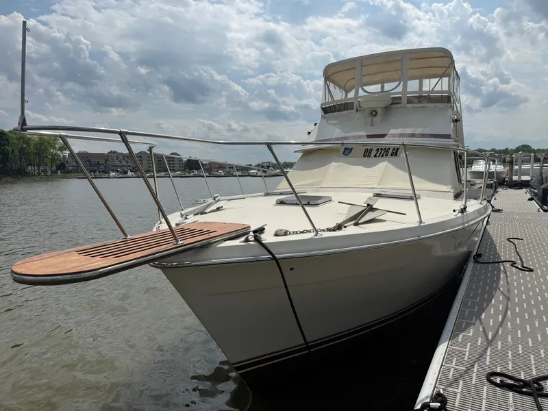 Slide: The Image of 1985 Trojan F36 boat docked by a lake under a cloudy sky. - 34