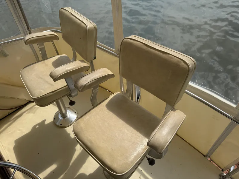 Slide: The Image of Two beige captain chairs on a 1985 Trojan F36 boat deck. - 4