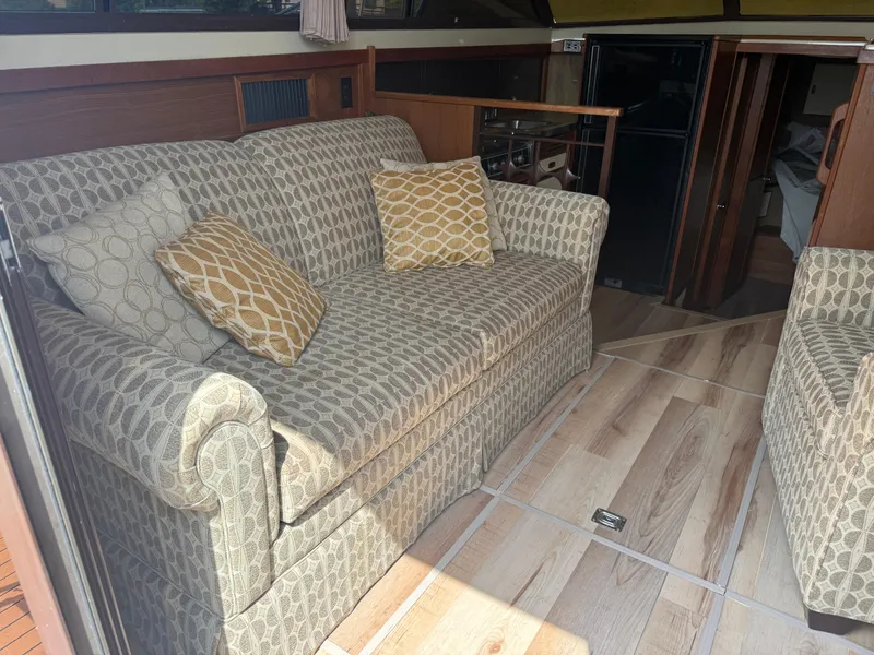 Slide: The Image of Interior of a 1985 Trojan F36 boat with patterned sofa and wooden flooring. - 6