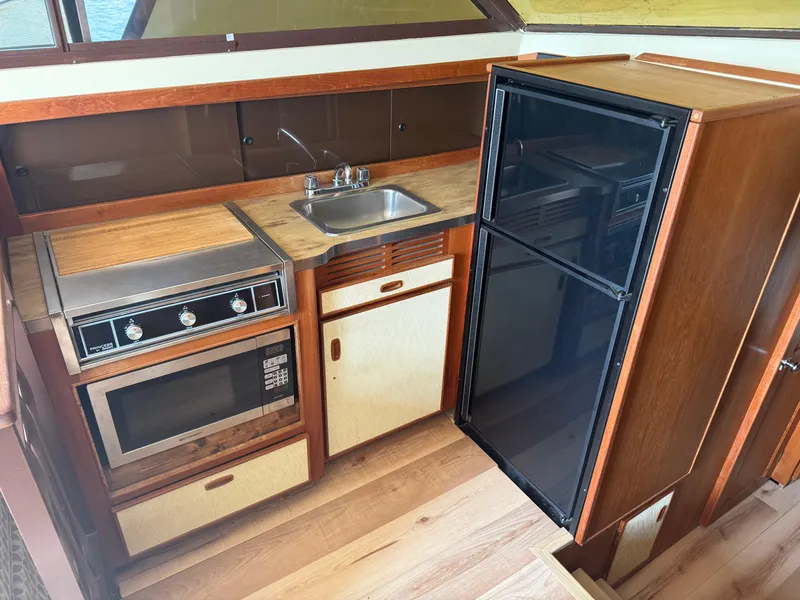Slide: The Image of 1985 Trojan F36 yacht kitchen with stove, sink, and refrigerator. - 7