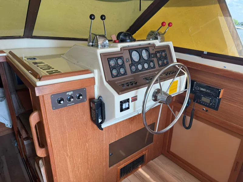 Slide: The Image of 1985 Trojan F36 boat helm with steering wheel, control panel, and wooden accents. - 8