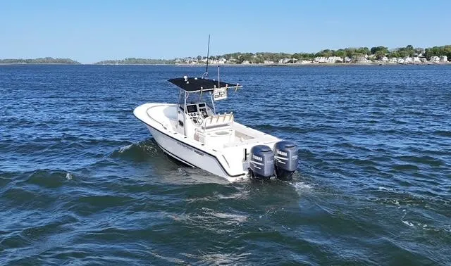 Slide: The Image of 2005 Pursuit 2570 Center Console boat on open water with dual engines. - 12