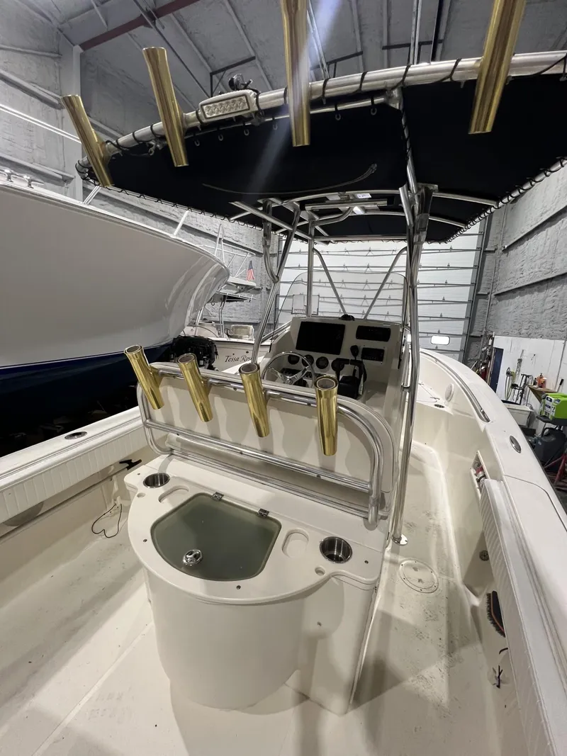 Slide: The Image of 2005 Pursuit 2570 Center Console boat with rod holders and control panel in a garage. - 17