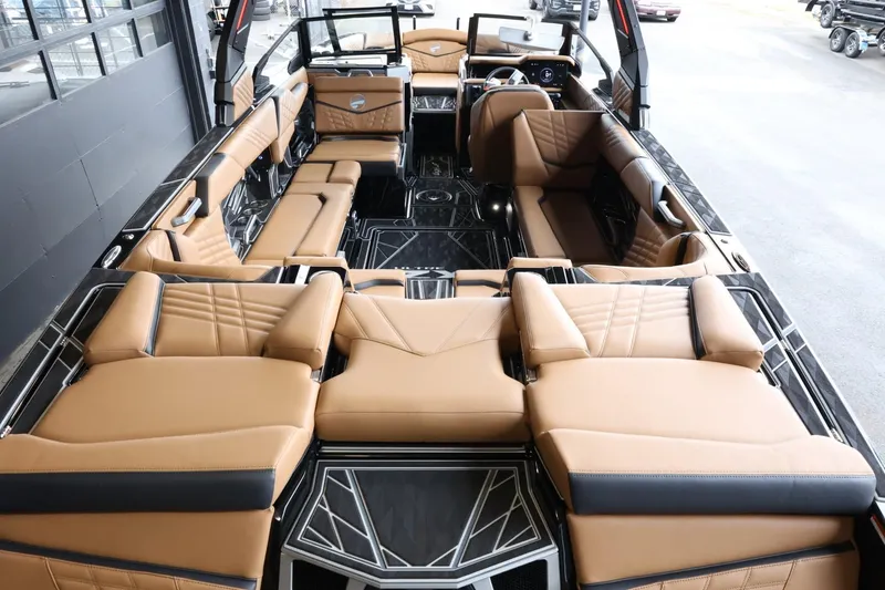 Slide: The Image of 2025 Tigé Ultré 25ZX boat interior with luxurious tan and black seating. - 12