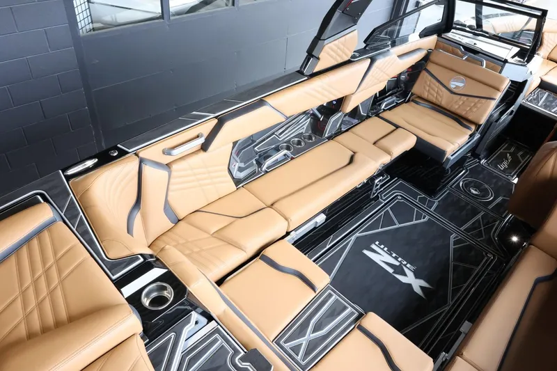 Slide: The Image of 2025 Tigé Ultré 25ZX boat interior with tan leather seating and sleek black accents. - 15