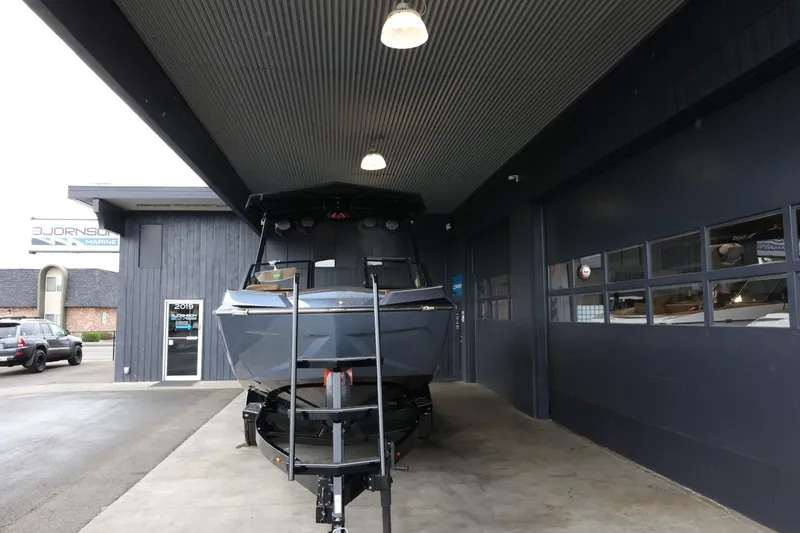 Slide: The Image of 2025 Tigé Ultré 25ZX boat parked under a covered area at a dealership. - 3