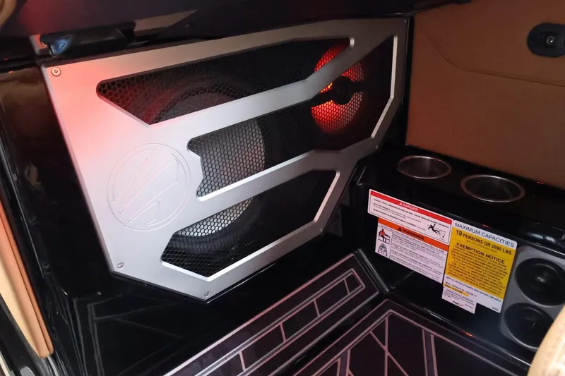 Slide: The Image of 2025 Tigé Ultré 25ZX interior speaker system with cup holders and safety labels. - 38