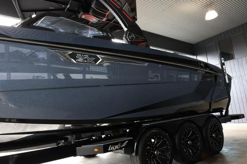 Slide: The Image of 2025 Tigé Ultré 25ZX boat on trailer in indoor showroom. - 5