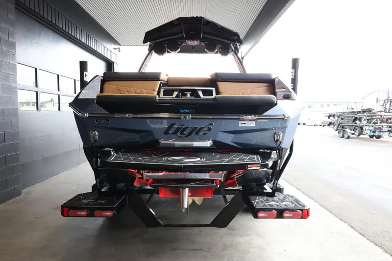 Slide: The Image of 2025 Tigé Ultré 25ZX boat rear view in a showroom setting. - 7