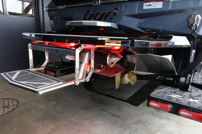 Slide: The Image of 2025 Tigé Ultré 25ZX boat rear view with illuminated platform and propeller. - 9