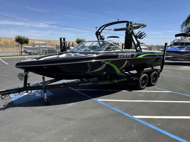 Slide: The Image of 2024 Sanger V215 S boat with sleek black and green design on a trailer. - 11