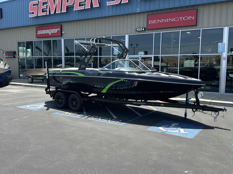 Slide: The Image of 2024 Sanger V215 S boat on trailer outside dealership, featuring sleek black design. - 2
