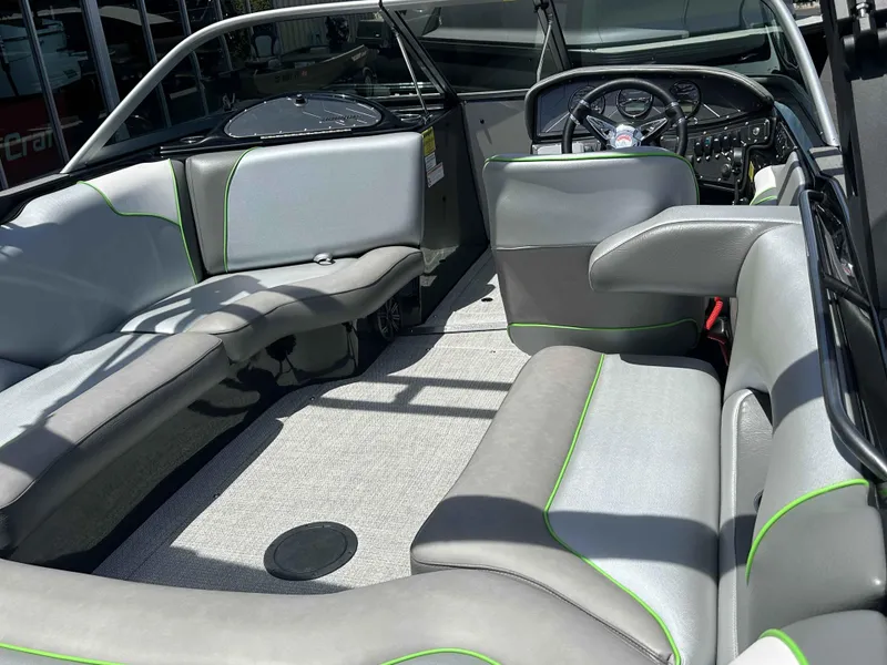 Slide: The Image of 2024 Sanger V215 S boat interior with gray and green seating, modern dashboard. - 6
