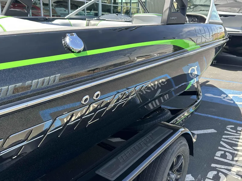 Slide: The Image of 2024 Sanger V215 S boat with sleek black and green design, parked on a trailer. - 8