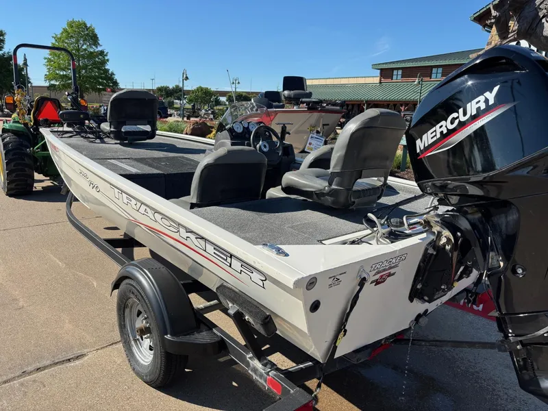 Slide: The Image of 2023 Tracker Pro 170 boat with Mercury engine on a trailer, parked outdoors. - 3