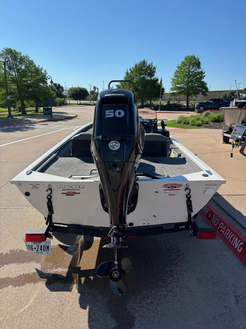 Slide: The Image of 2023 Tracker Pro 170 boat with 50 HP engine, parked outdoors on a sunny day. - 4