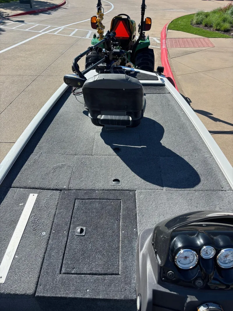 Slide: The Image of 2023 Tracker Pro 170 boat interior with dashboard and seating, parked on pavement. - 5