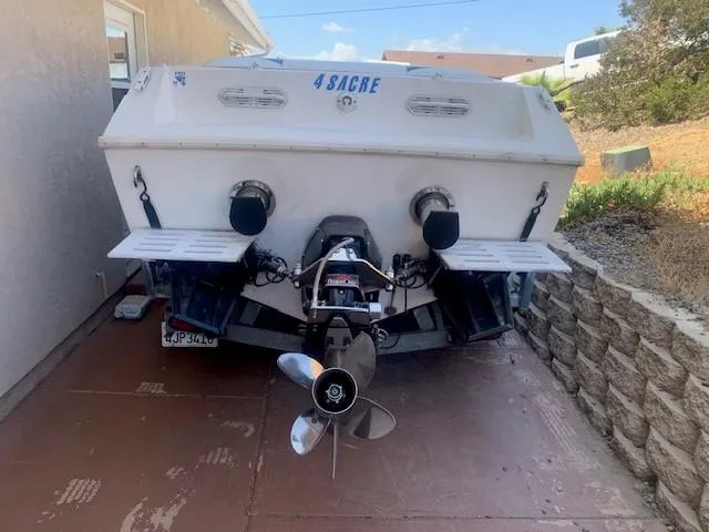 Slide: The Image of Rear view of a 1995 Ultimate Warlock 29 World Class boat in a driveway. - 4