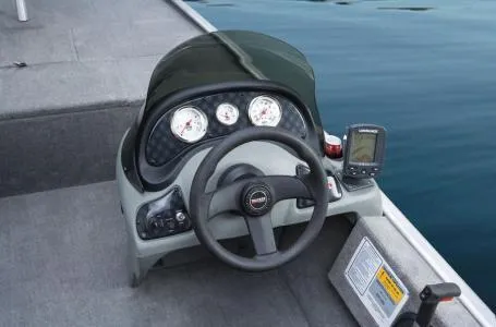 Slide: The Image of 2013 Tracker Pro 170 boat dashboard with steering wheel and gauges on calm water. - 5