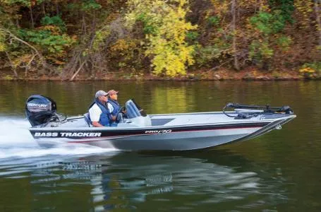 Slide: The Image of 2013 Tracker Pro 170 boat speeding on a lake with two passengers, surrounded by autumn foliage. - 9