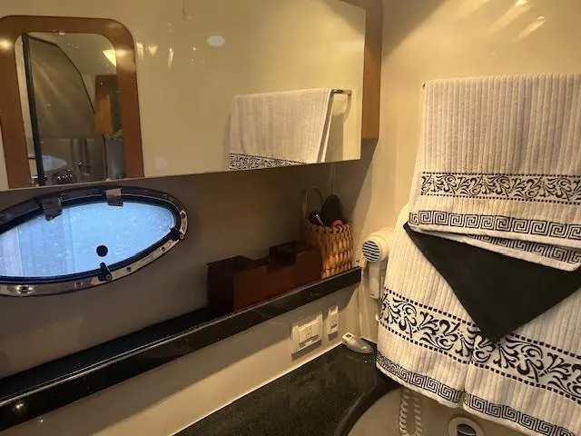 Slide: The Image of 2003 Regal 3860 yacht bathroom with mirror, porthole, and decorative towels. - 17