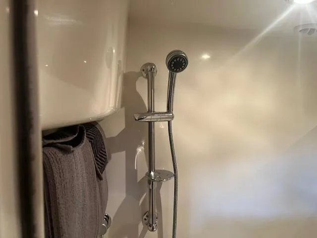 Slide: The Image of Shower area in a 2003 Regal 3860 boat, featuring chrome fixtures and a towel. - 33