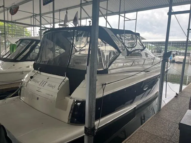 Slide: The Image of 2003 Regal 3860 yacht docked in a marina under a covered shelter. - 5