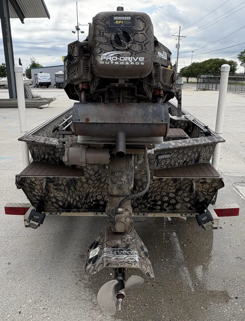 Slide: The Image of 2024 Pro-Drive X Series boat with camo design and outboard motor, rear view. - 10