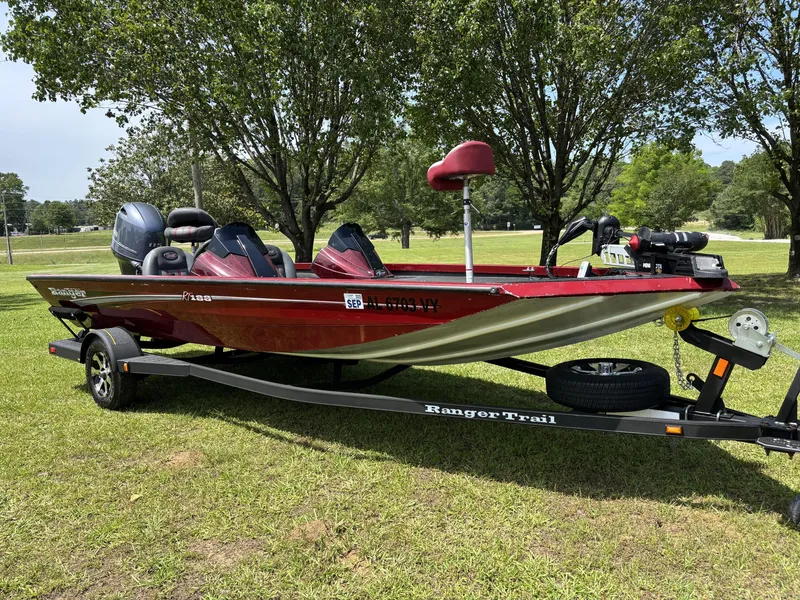 Slide: The Image of 2015 Ranger RT188 boat on trailer, parked on grass with trees in background. - 2