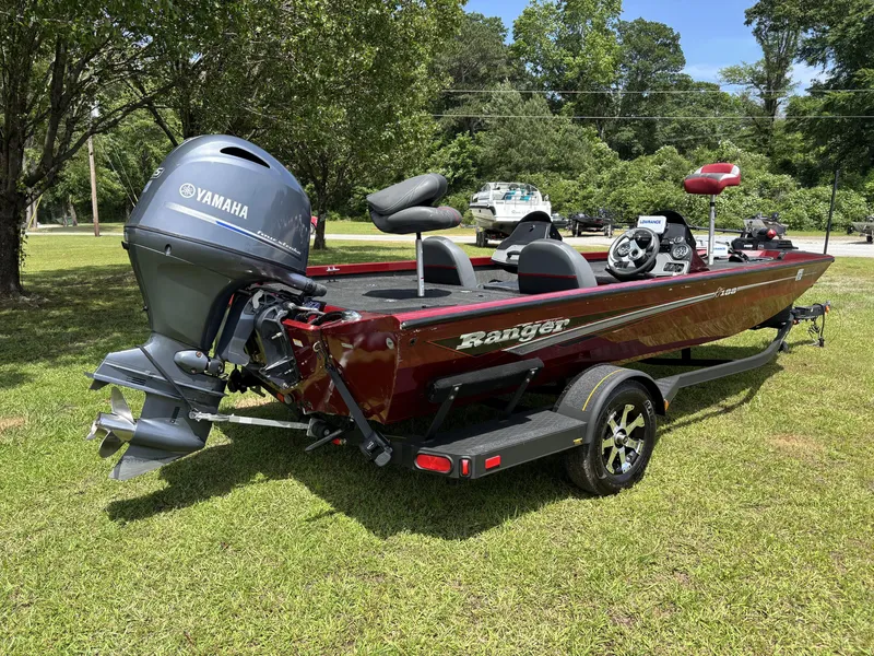 Slide: The Image of 2015 Ranger RT188 boat with Yamaha motor on grassy area, surrounded by trees. - 5