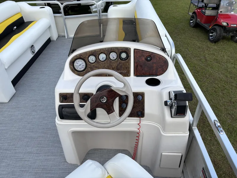 Slide: The Image of 2007 Triton 220 Gold boat dashboard with steering wheel and control panel. - 10
