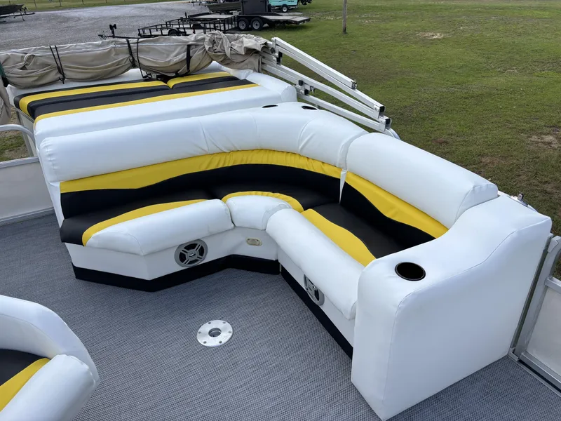 Slide: The Image of 2007 Triton 220 Gold boat interior with white, yellow, and black seating on gray carpet. - 4