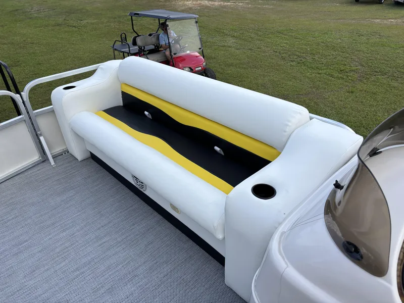 Slide: The Image of White and yellow seating on 2007 Triton 220 Gold boat, with golf cart in background. - 6