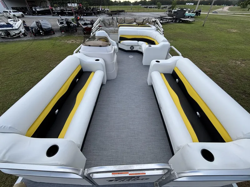 Slide: The Image of 2007 Triton 220 Gold pontoon boat with yellow and black seating, parked outdoors. - 9