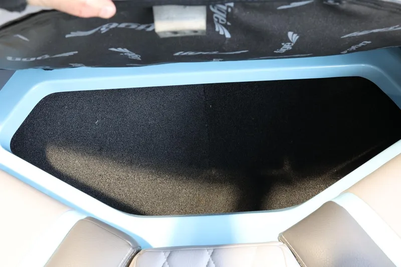 Slide: The Image of 2022 Tigé 25ZX boat storage compartment with open lid, showcasing interior space. - 19