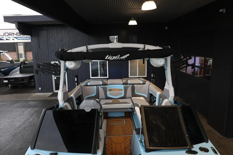 Slide: The Image of 2022 Tigé 25ZX boat with sleek interior design, showcased in a modern showroom. - 21