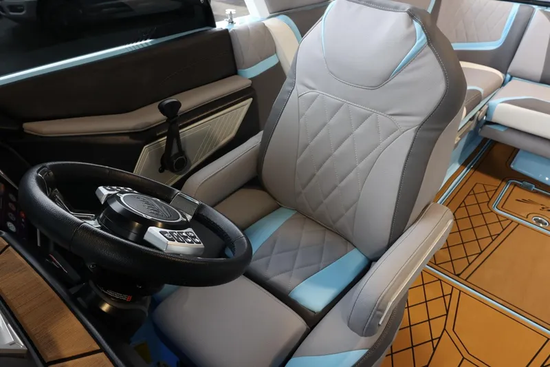 Slide: The Image of 2022 Tigé 25ZX boat interior with modern steering wheel and stylish seating. - 24