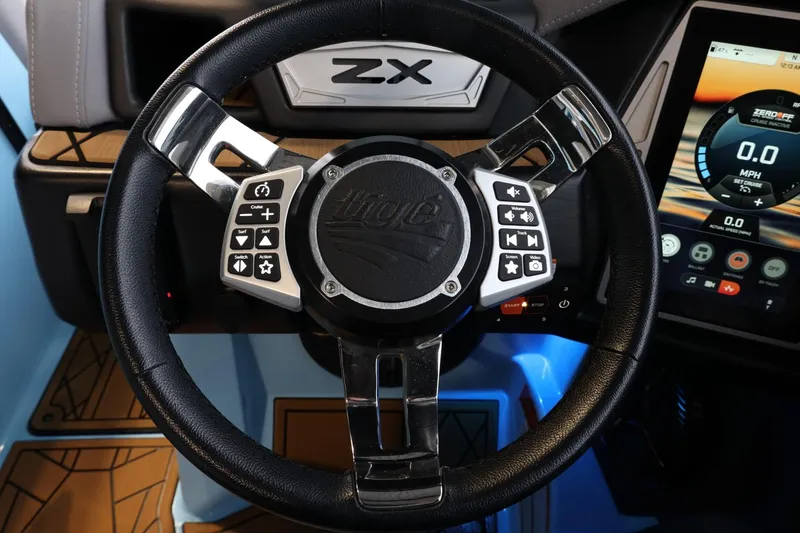 Slide: The Image of Steering wheel of 2022 Tigé 25ZX boat with control buttons and digital display. - 25