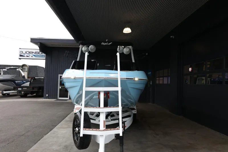 Slide: The Image of 2022 Tigé 25ZX boat on trailer at dealership entrance. - 3
