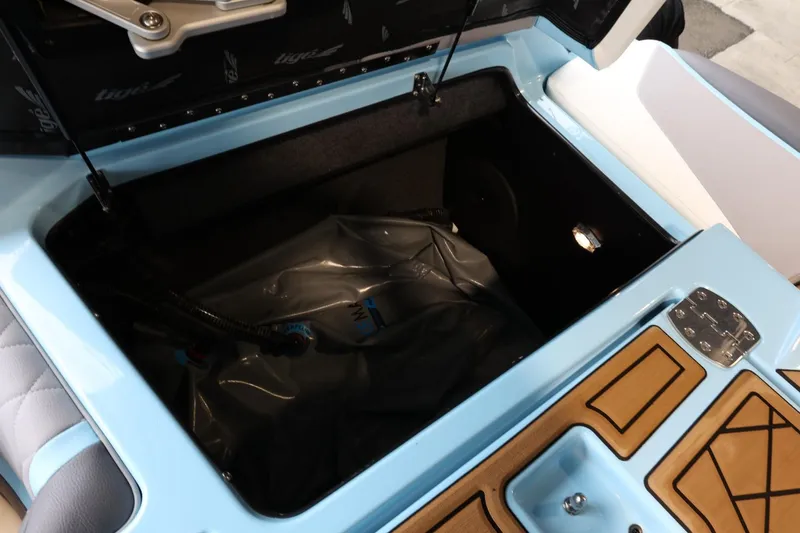 Slide: The Image of 2022 Tigé 25ZX boat storage compartment with open lid, showcasing interior space. - 42