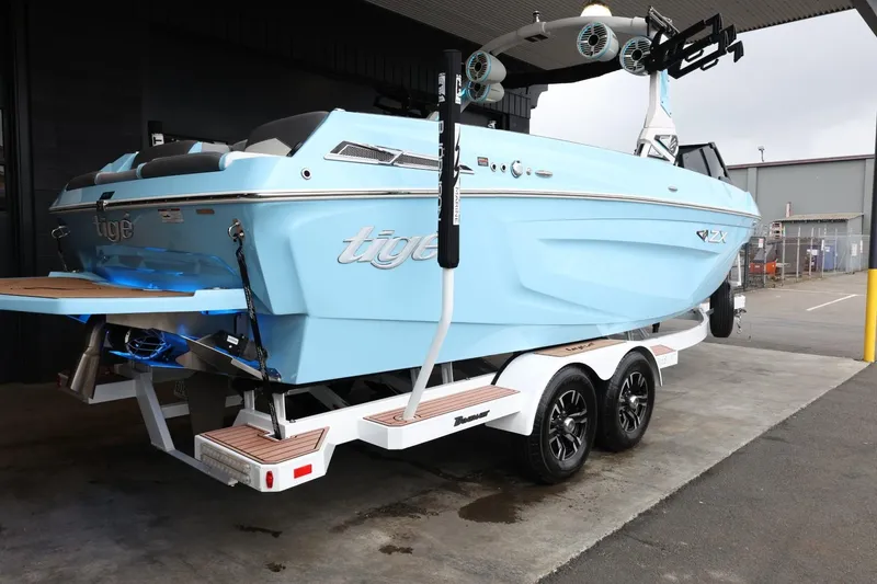 Slide: The Image of 2022 Tigé 25ZX boat on trailer, light blue, parked in a garage. - 7