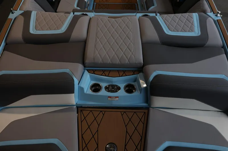 Slide: The Image of 2022 Tigé 25ZX boat interior with gray and blue cushioned seating and cup holders. - 8
