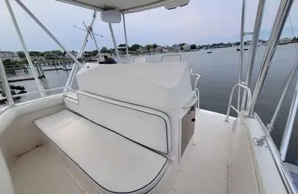 Slide: The Image of 2005 Cabo 35 Flybridge Sportfisher boat interior with seating, overlooking calm waters. - 12