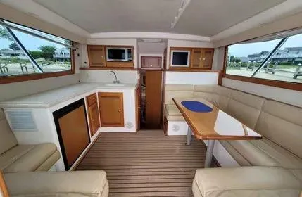Slide: The Image of Interior of 2005 Cabo 35 Flybridge Sportfisher with seating, table, and kitchenette. - 13