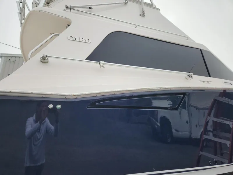 Slide: The Image of 2005 Cabo 35 Flybridge Sportfisher boat with sleek design and reflective windows. - 3