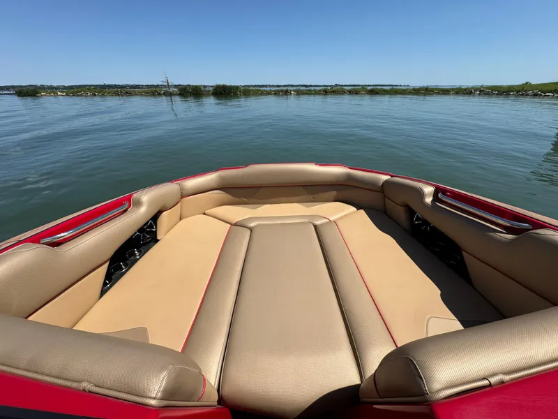 Slide: The Image of 2022 Moomba Makai boat interior with tan seating on a calm lake. - 10