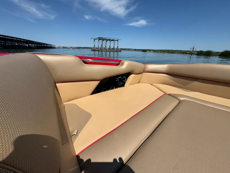 Slide: The Image of 2022 Moomba Makai boat interior with tan upholstery on a sunny day by the water. - 11