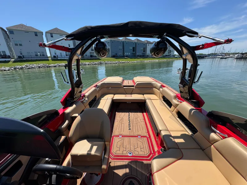Slide: The Image of 2022 Moomba Makai boat interior with tan seating, red accents, and lake view. - 13
