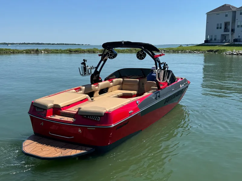 Slide: The Image of 2022 Moomba Makai boat on calm water, featuring red exterior and beige seating. - 5