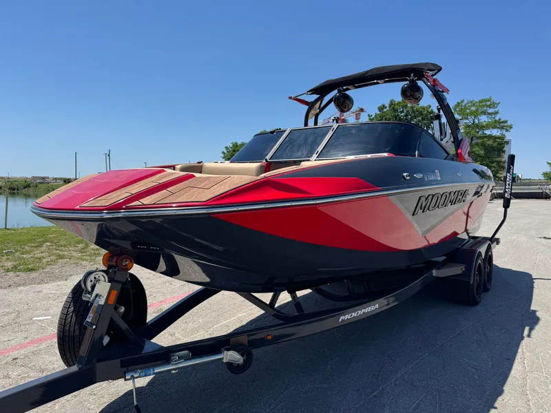 Slide: The Image of 2022 Moomba Makai boat on trailer, red and black design, parked outdoors. - 8